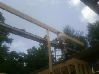 Carpenter setting a ridge beam over a new addition frame — Ice Dam Removal by Roofing Brothers in Bourbonnais