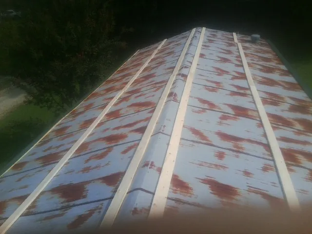 Rusted metal roof panels with new wood purlins before replacement — Storm Damage Roof Repair in Bourbonnais by Roofing Brothers