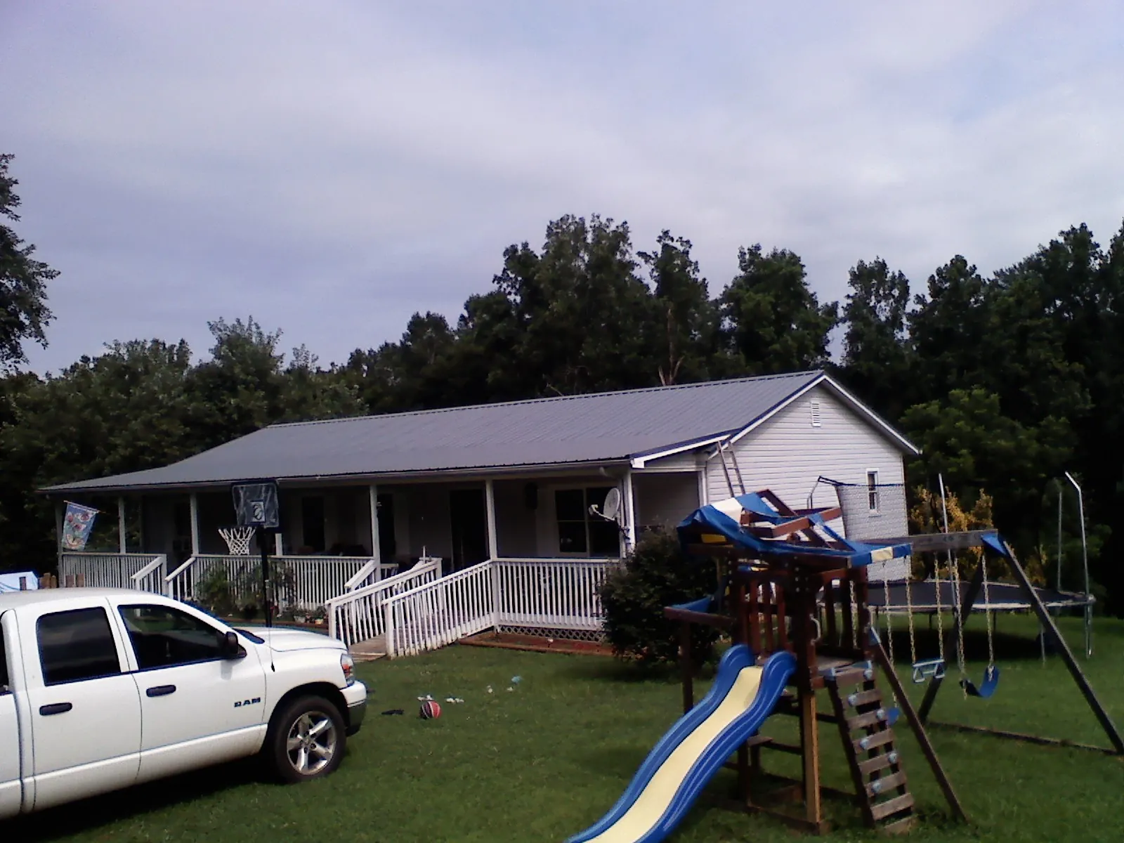 Dark metal roof on a country home with a full length front porch in Bourbonnais