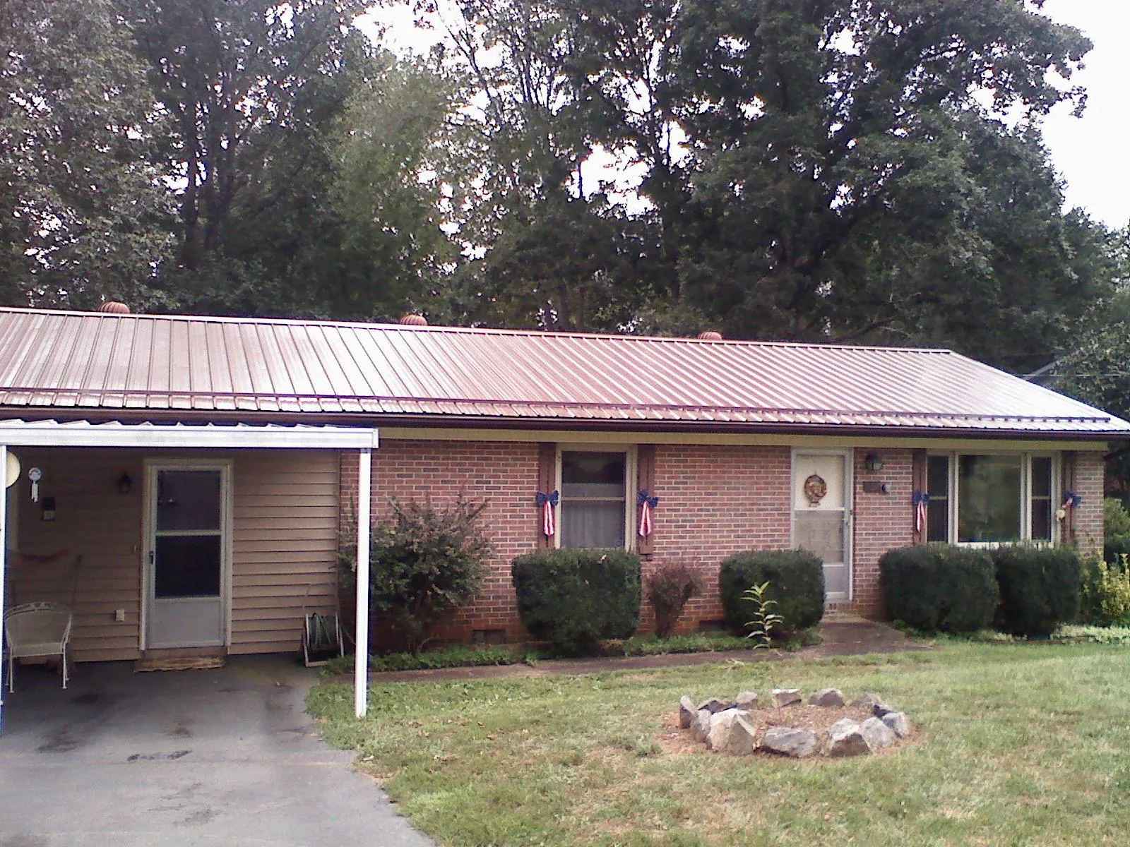 Bronze metal roof and carport on a brick ranch home — Roof Repair work by our crew in Bourbonnais