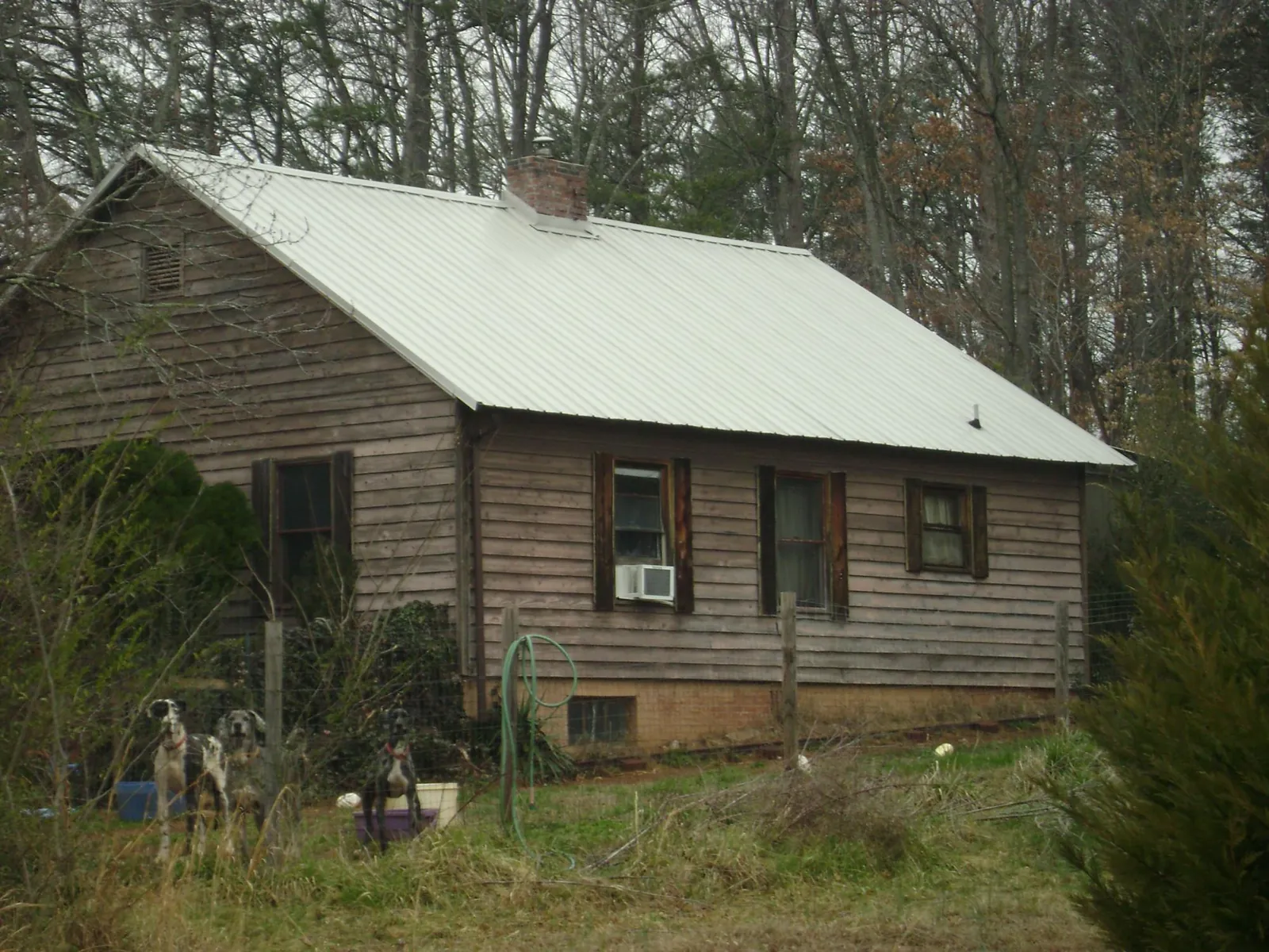 White metal roof on an old wood sided farmhouse, from a Metal Roof Installation job in Bourbonnais